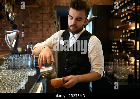 Ein talentierter bärtiger Mann, der frische Cupuchino vorbereitet, Nahaufnahme, Beruf, Beruf, Intereten, Lifestyle Stockfoto