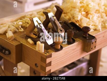 Antiker Holztäfler mit Holzspäne. Tischler Schrankbauer Handwerkzeuge auf der Werkbank. Stockfoto