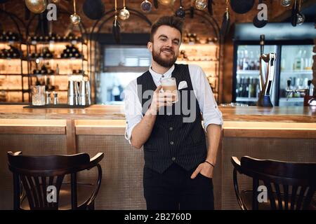 Eleganter Mann in stilvollem Anzug, der die Hand an der Tasche hält und die Kamera betrachtet. Nahaufnahme. Stockfoto