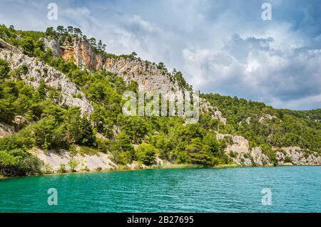 Grüne Hügel mit Wald rund um den Fluss Krka im wunderschönen Nationalpark Krka, Kroatien. Touristische Boote fahren auf dem Fluss entlang, um Skradinski buk waterfal anzukommen Stockfoto