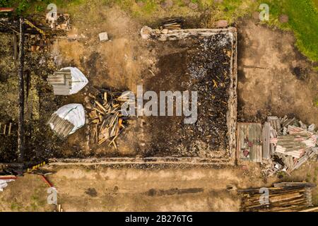 Drohnenblick auf das abgebrannte Haus und seine Ruinen. Stockfoto