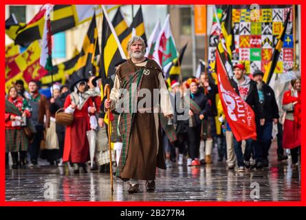 Ein Mann, der als Dewi Sant verkleidet ist, führt die St David's Day Parade in Cardiff an, wo Hunderte von Menschen in der Feier des Schutzpatrons von Wales, Dewi Sant (Saint David in English), der walisischer Bischof von Mynyw (heute St Davids) im 6. Jahrhundert war, durch die Stadt marschieren. Stockfoto