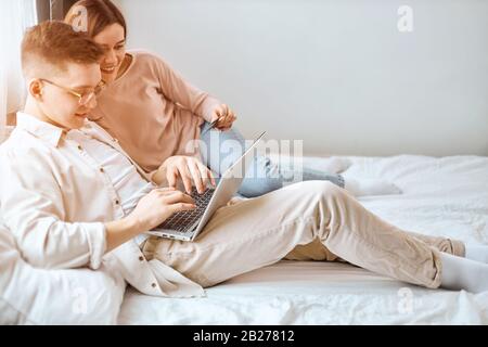 Junge Familie, die online Geld verdient, Nahansicht Foto: Glückliches Paar zahlt Zahlungen, Darlehen rechtzeitig zurückzahlen Stockfoto