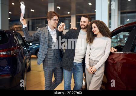 Lächelnde Jugendliche können nicht an ihren Erfolg glauben, Nahaufnahme. Paar freut sich über neues Auto. Geschenk, Geschenk. Stockfoto