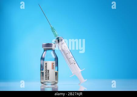 Impfstoff gegen Corona-Viren/Impfstoffkonzept mit Fläschchen und Spritze auf blauem Hintergrund Stockfoto