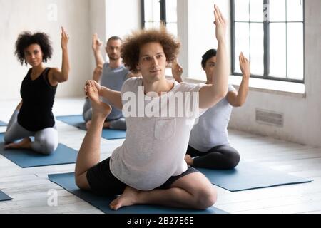 Eine Gruppe von Leuten, die einsagenhafte King Pigeon Asana ausführen Stockfoto