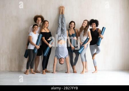 Durchgehender sportlicher Mensch mit Matten, die in der Nähe der Wand stehen Stockfoto