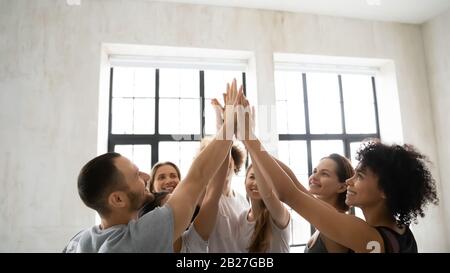 Eine Gruppe sportlicher Vielvölkerer, die fünf hohe Einigkeit zeigt Stockfoto