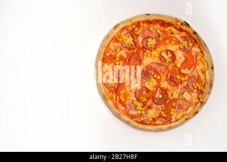 Pfefferoni- oder hawaiianische Pizza mit Ananasbits. Nehmen Sie Lebensmittel mit knackigen Rändern weg. Pizza mit Speck, Pfefferoni, Tomaten und Mais isoliert auf weißem Hintergrund. Fast Food und italienisches Kochkonzept. Stockfoto