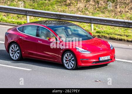 2019 Red Tesla Model 3 Performance AWD; Elektrizität Fahrzeugverkehr, Transport, moderne Fahrzeuge, EV-Limousinen, Fahrzeug auf britischen Straßen, Motoren, Autofahren auf der Autobahn M6 Stockfoto