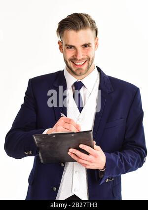 Mann in Anzug oder Kaufmannszeichen dokumentieren per Stift. Geschäftsmann mit jungen Aussehen und klassischem Outfit hält Pad und Stift. Geschäftsdokumente Konzept. Mann mit fröhlichem Gesicht isoliert auf weißem Hintergrund. Stockfoto