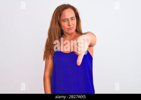 Reife Frau mittleren Alters, die auf weißen Hintergrund isoliert unzufrieden und wütend, Ablehnung und negativ mit Daumen nach unten Geste. Schlecht Stockfoto