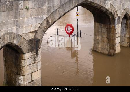 Torbogen entlang der River Ouse und Lendal Bridge in York. Das Hochwasser hat den Weg und den Fahrradpark überdeckt. Stockfoto