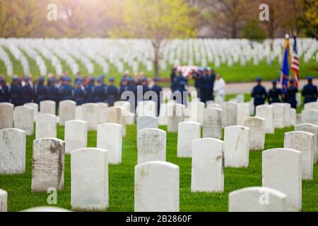 US-Grabzug mit Soldaten und Fahne im Hintergrund auf dem Militärfriedhof Stockfoto