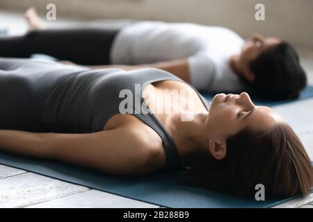 Junge Frau während des Yoga-Kurses, die in Shavasana Liegt, Posieren Nahaufnahme Stockfoto