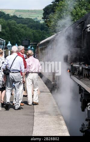 Bahnpassagiere, die in der Dampfstraßenbahn der North Yorkshire Moors am Bahnhof Goathland an den North York Moors in Bri einsteigen Stockfoto