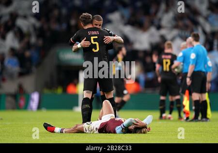 John Stones (links) und Kyle Walker von Manchester City feiern, wie Jack Grealish von Aston Villa nach dem Carabao-Cup-Finale im Wembley-Stadion, London, niedergeschlagen wird. Stockfoto