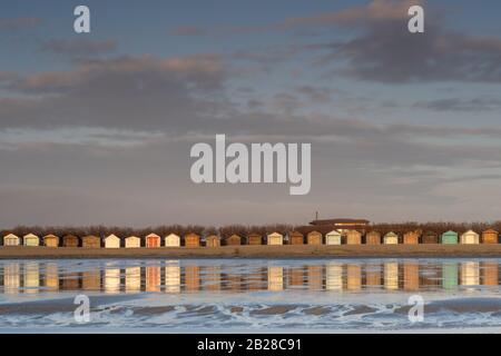 West Wittering Strandhütte Reflexionen im nassen Sand und auf dem Dach des neuen Cafés. Stockfoto