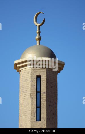 Messing- oder goldfarbenes muslimisches Halbmondsymbol auf der Goldkuppel oben auf dem Minarett der Moschee Stockfoto