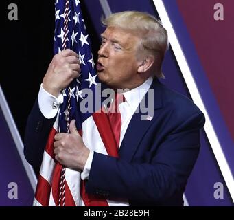 Washington DC, USA. Februar 2020. Präsident Donald Trump umarmt und küsst die amerikanische Flagge, als er am Samstag, den 29. Februar 2020, in National Harbor, Maryland, Bemerkungen auf der Conservative Political Action Conference (CPAC) abschließt. Tausende konservative Aktivisten, gewählte Funktionäre und Experten versammelten sich, um Sprecher zum Thema "Amerika gegen den Nationalsozialismus" zu hören. Credit: UPI/Alamy Live News Stockfoto