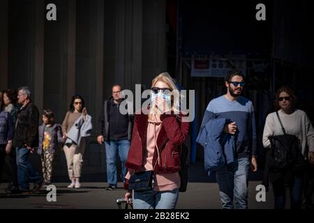 Eine Frau, die einen Kopf mit Gesichtsmaske an die Aerobus-Linie trägt.Das Salut-Ministerium berichtet von neuen Fällen von Coronavirus in der autonomen Gemeinschaft Katalonien (Spanien), die die Zahl auf zwölf Betroffene erhöhen. Die Zahl der Touristen in Barcelona ist gering. Sanitärmasken werden in der Bevölkerung häufiger eingesetzt. Stockfoto