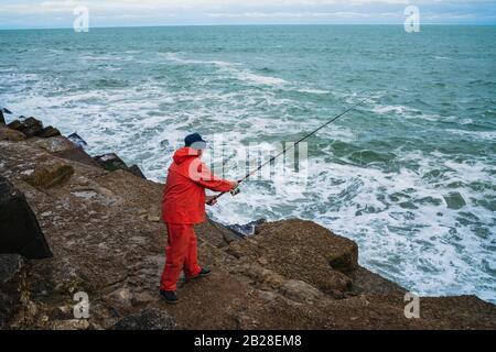 Porträt eines alten Mannes, der im Meer fischt. Angelkonzept. Stockfoto