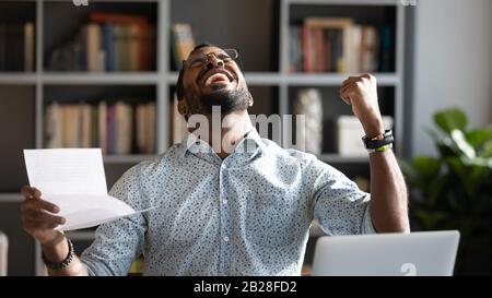 Überfreudiger junger gemischter Rennmann, der unglaublichen Triumph feiert. Stockfoto