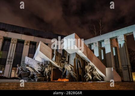 Warschau, Polen - 27. Dezember 2019: Warschauer Aufstandsdenkmal (Polnisch: Pomnik Powstania Warszawskiego) und Oberster Gerichtshof in der Nacht Stockfoto