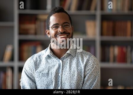 Kopfschussporträt des glücklichen jungen afroamerikanischen Geschäftsmannes. Stockfoto