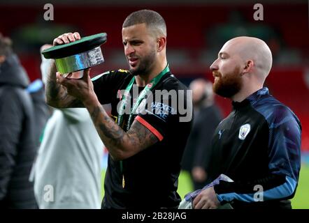 Der Kyle Walker (links) von Manchester City liest den Text, der auf der Trophäe des Carabao Cups eingraviert ist, nachdem er das Finale des Carabao Cup im Wembley-Stadion in London gewonnen hat. Stockfoto