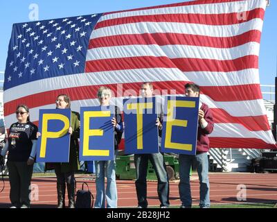 Arlington, USA. Februar 2020. Anhänger des demokratischen US-Präsidentschaftskandidaten Pete Buttigieg posieren bei einer Wahlkampfveranstaltung vor der amerikanischen Flagge. Der Wahlkampf vor den Wahlen der US-Demokraten läuft auf den Höhepunkt: Wird es nach dem "Superdienstag" klarer sein, welchen US-Demokraten Präsident Trump in Frage stellen wird? Wenn nicht, könnte dies für seine Gegner tödlich sein. (Zu dpa-KORR.: "Hoffnung auf Trumps Niederlage - Aber wer kann es schaffen?") Credit: Lena Klimkeit / dpa / Alamy Live News Stockfoto