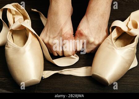 Weibliche Ballerina Füße mit Spitzen nach dem Tanz auf einem Holzboden Nahbild Stockfoto