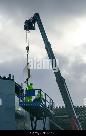 Sandwichpaneele Wandmontage mit Kran und Scherenhub Stockfoto