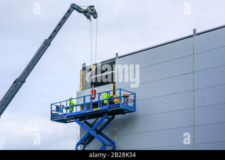 Sandwichpaneele Wandmontage mit Kran und Scherenhub Stockfoto