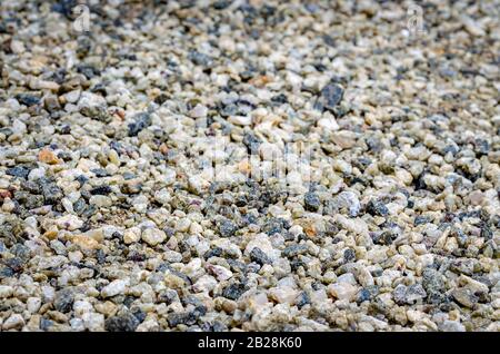 Mehrfarbige, glatte Kieselsteine auf dem Boden als Hintergrund. Stockfoto