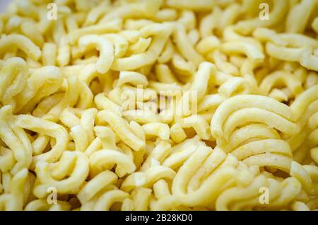 Nahaufnahme von Instantnudeln, die aus der Packung entnommen wurden und fertig gekocht werden können. Hintergrund. Stockfoto