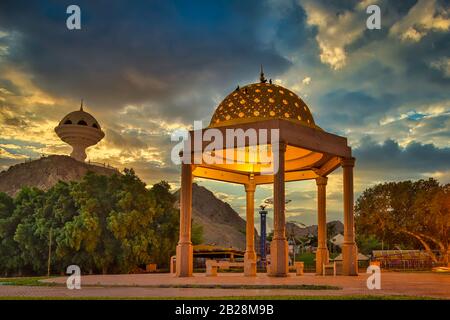 Gazebo Dome badete in goldenem Licht zusammen mit dem Weihrauchbrenner Denkmal am Abend. Aus Maskat, Oman. Stockfoto