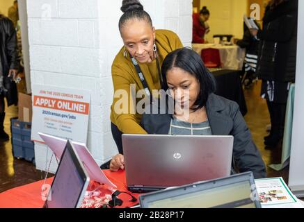 Detroit, Michigan, USA. März 2020. Juanita Brown (Stand), eine Census Job Recruiterin, hilft einer Frau, sich während einer Jobmesse in der Martin Evers Missionary Baptist Church beim U.S. Census zu bewerben. Kredit: Jim West/Alamy Live News Stockfoto