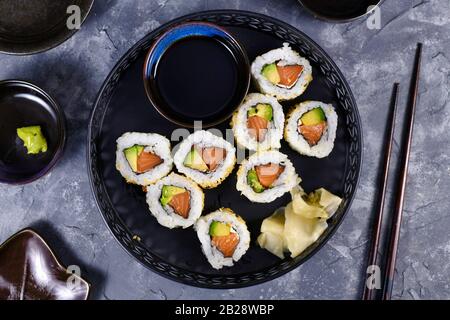 Sushi california Rolls legten rohen Lachsfisch, Avocado, Frischkäse und mit Sesam bestreichen Stockfoto