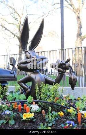 Bronzestatue von Bugs Bunny, in dem er auf seinem üblichen Karotten, der auf dem Leicester Square installiert ist, schampeliert, um Londons Filmindustrie 2020, Großbritannien, zu feiern Stockfoto
