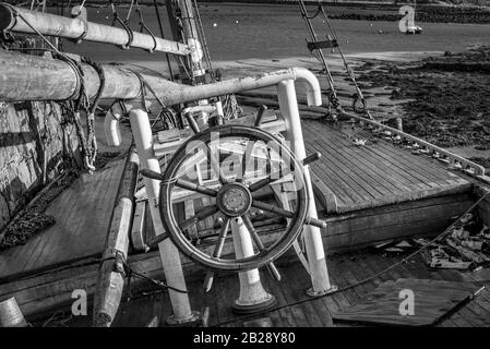 Das Steuerrad und das Rad eines alten forgoton-Segelbootes aus Holz, das an der Westküste Irlands festgemacht wurde Stockfoto