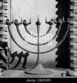 Menorah, die siebenarmige jüdische Lampe und ihr Schatten auf einem Grab auf Dem Monumentalen Friedhof in Mailand, Italien Stockfoto