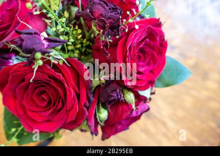 Eine kleine Vase aus roten Rosen und anderen Blumen bildet ein dekoratives Herzstück. Stockfoto