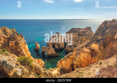 Türkisfarbene Meeresbucht zwischen Felsen und Klippen in Ponta da Piedade bei Lagos, Region Algarve, Portugal, Europa Stockfoto