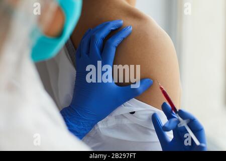 Nahaufnahme der Krankenschwester, die während der Behandlung in der Klinik einen Impfstoff an den männlichen Patienten abgegeben hat, Kopierraum Stockfoto