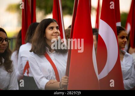 Izmir, Türkei - 29. Oktober 2016. Rote türkische Flaggen und junge Studentinnen halten sie bei der Zeremonie am Cumhuriyet Square Alsancak in Izmir. In Der Republik Stockfoto