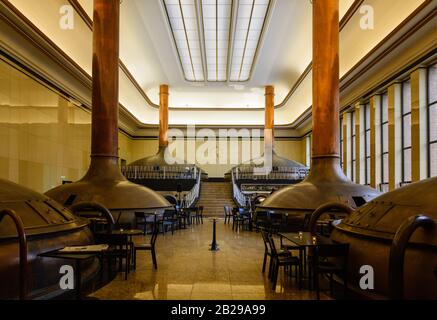 Innenansicht des Cafés, das vom alten Brauereigebäude mit hohen Decken, einem Oberlicht und einem antiken Kupferbrühtank in KINDL renoviert wurde. Stockfoto