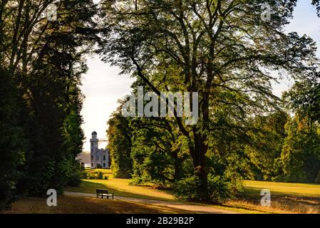 Ruhiger Blick auf die Burg auf der Pfaueninsel und Szenenatmosphäre bei Sonnenuntergang über dem Park auf der Pfaueninsel in Berlin. Stockfoto