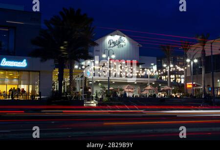 Leichte Wege auf einer City Road mit Beleuchteten Gebäuden, bei denen die Gäste nachts in Restaurants am Pacific Coast Highway speisen können. Stockfoto