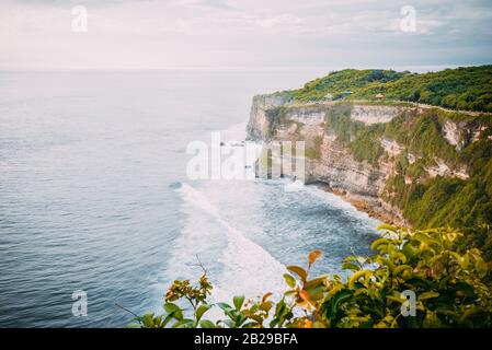 Küstenlinie mit Wellen an den Klippen an einem Sommertag als Blick vom Uluwatu-Tempel in Bali Indonesien Stockfoto